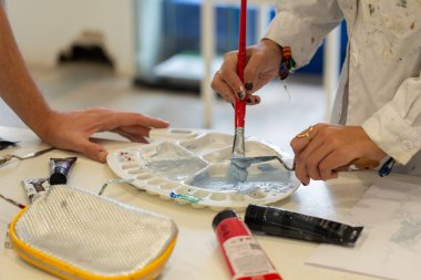 Resim atölyesinde paletli bir ressam.