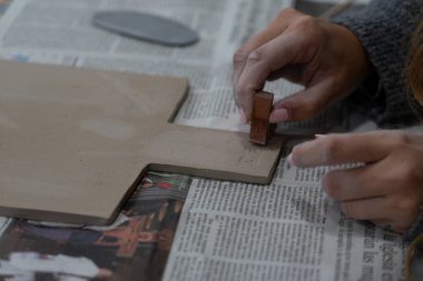 Çömlek atölyesinde kadınların elleri kilin üzerine damga vuruyor.