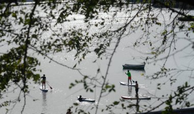İnsanlar denizde kürek çekiyor.