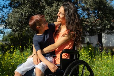 Mutlu tekerlekli sandalyeli anne ve oğlu doğada
