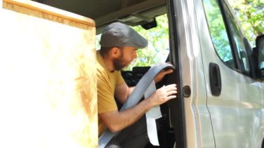 Karavan modifiye işinde bir karavanı soğuktan koruyan bir adam.