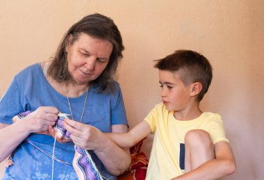 Büyükannem torununa örgü örmeyi öğretiyor.