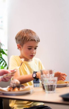 Kafkasyalı çocuk restoranda pizza yiyor.