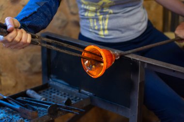 Esnaf atölyede bir parça el yapımı cam yapıyor.