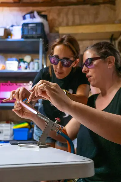 stock image Woman in a glass jewelry creation workshop with the teacher helping her