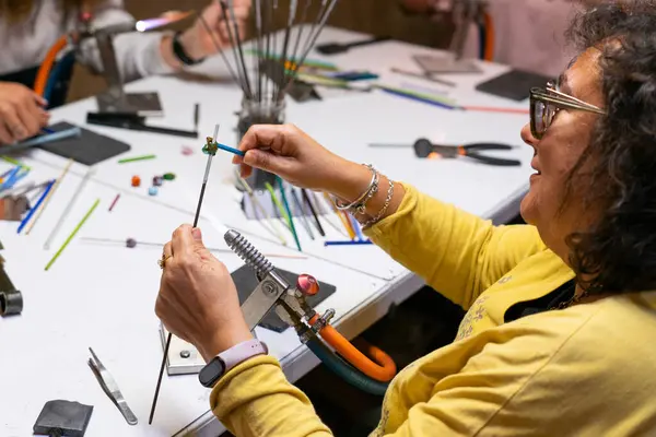 stock image Woman learning to make handmade glass jewelry in a workshop