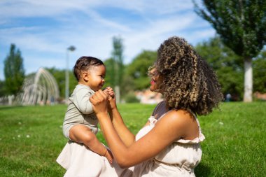 Afro anne 6 aylık bebeğiyle parkta oynuyor.