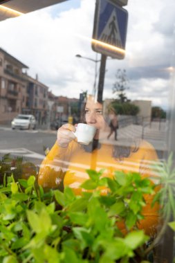 Pencereden dışarı bakan bir kadın.