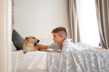 Kafkas çocuk köpeğiyle yatakta dinleniyor.