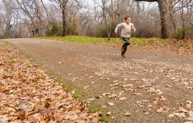 Sonbahar manzarasında koşan bir çocuk