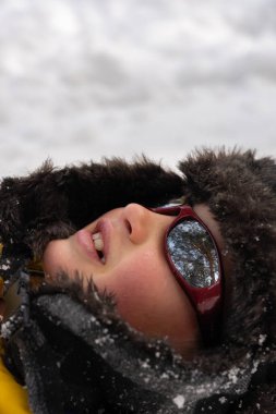 Kar gözlüğü ve kış şapkası takmış bir çocuğun portresi.