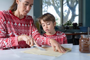 Anne ve oğul Noel tatlısı pişiriyor.