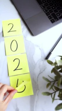 Yeni yılın 2025 sayısıyla birlikte bir dizüstü bilgisayarın yanına koy. 2024 'ten 2025' e adım