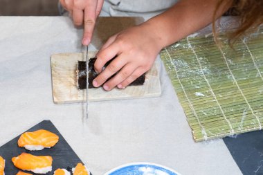 Suşi kesen bir çocuğun elleri.