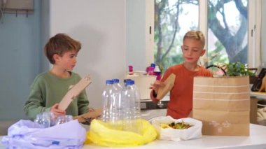 Genç çocuklar mutfakta atık ayıklama işleriyle uğraşıyorlar. Eko kavramı
