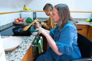 Disabled mom cooking with her grandson, promoting accessibility and inclusion in the kitchen clipart