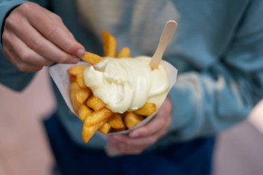 Çocuk mayonezli Hollanda usulü patates kızartması yiyor. Popüler bir fast food atıştırmalığı.