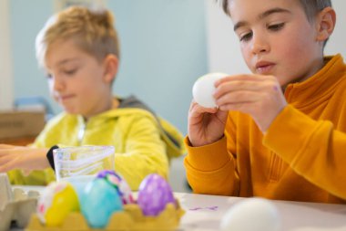 Çocuklar Paskalya yumurtalarını boyuyor. Paskalya kutlaması için hazırlanıyorlar.
