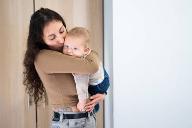 Anne, evdeki hassas bir anda bebeğine sevgi ve şefkat gösteriyor.