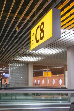 Illuminated gate c8 sign displaying flight details and guiding passengers to their designated boarding area within a modern airport terminal clipart