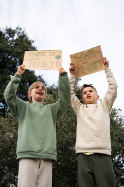 İki genç eylemci protesto işaretleri tutarak, çevre korumasını savunarak iklim değişikliği hakkında farkındalık yaratıyor
