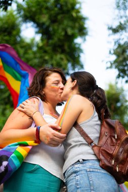 İki kadın öpüşüyor, bir gurur etkinliğinde aşkı ve eşitliği kucaklıyor, lgbtq + haklarını ve kabulü simgeliyor.