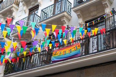 Gurur aylarında balkon süsleyen gökkuşağı bayrağı ve renkli üçgen flamalar, lgbtq + hakları ve kutlamaları sembolize ediyor
