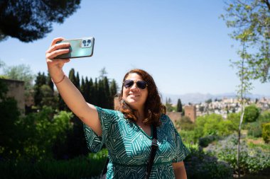 Turist akıllı telefon tutuyor ve selfie çekiyor. Yaz tatilinin tadını çıkarıyor. 