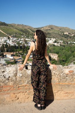  Güneşli bir günde panoramik manzaranın tadını çıkaran bir kadın.