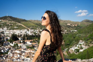 Granada şehri ve çevresindeki tepeler üzerindeki panoramik manzaraya hayran bir kadın.