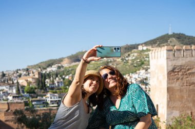 Granada, İspanya 'da akıllı telefonla selfie çeken iki kadın turist.