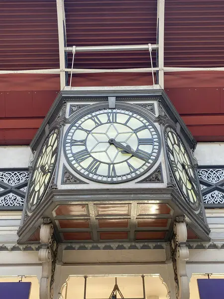 Londra 'nın Paddington İstasyonu' ndaki tarihi, dört taraflı saatin benzersiz bir görüntüsü. Açı, saatin destek yapısının ve ayrıntılı yüzlerin karmaşık işçiliğini ve geometrik örüntülerini vurgular.. 