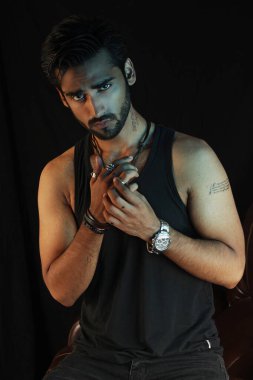 Stüdyoda dövmesi olan yakışıklı sakallı genç bir adam.