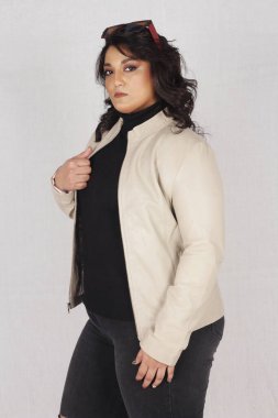 Siyah bluzlu ve beyaz ceketli bir kadın.