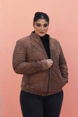 Kahverengi ceketli ve siyah pantolonlu bir kadın.