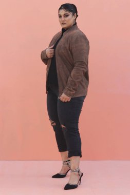 Kahverengi ceketli ve siyah pantolonlu bir kadın.