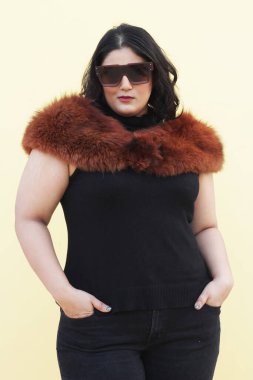 Siyah bluzlu ve kahverengi kürklü bir kadın.