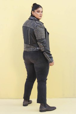 Siyah ceketli ve kot pantolonlu bir kadın.