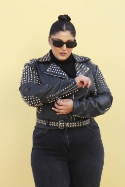 Siyah ceketli ve güneş gözlüklü bir kadın.