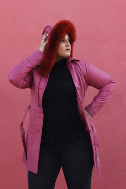 Pembe ceketli ve kırmızı şapkalı bir kadın.