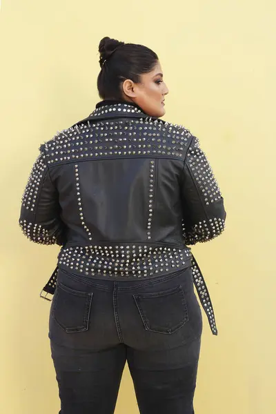 Siyah ceketli ve kot pantolonlu bir kadın.