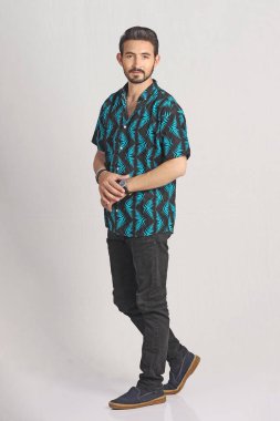 Gri sakallı genç yakışıklı adam poz veriyor.