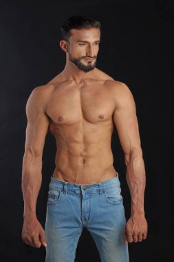 Kot pantolonla poz veren kaslı vücutlu yakışıklı adam..