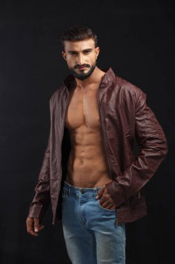 Stüdyoda poz veren deri ceketli yakışıklı sakallı adamın portresi.