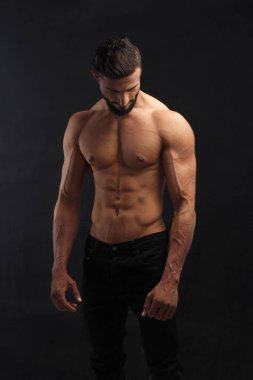 Koyu arkaplanda altı paket bira olan kaslı bir adam..