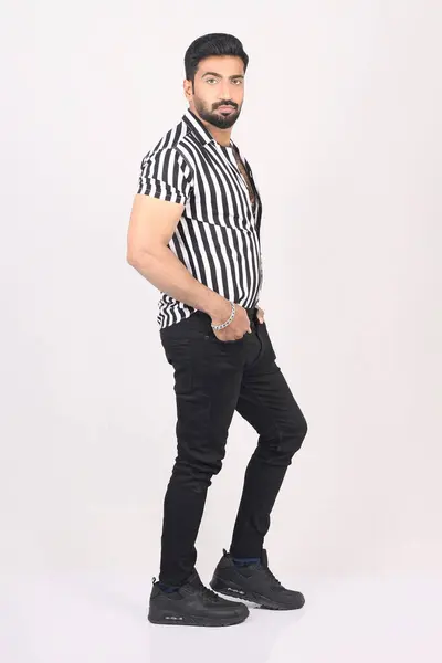 Gri arka planda genç ve yakışıklı bir Hintli.