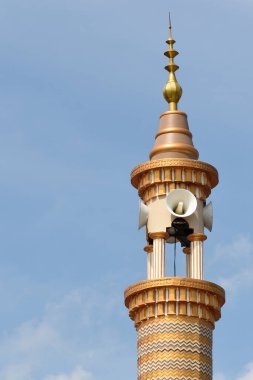 Hoparlörlerle donatılmış bir caminin üst kısmı.