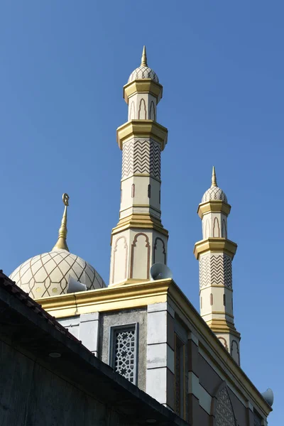 İki minaresi ve mavi gökyüzü arkaplanı olan güzel bir cami.