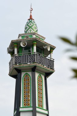 Hoparlörlerle donatılmış bir caminin üst kısmı.