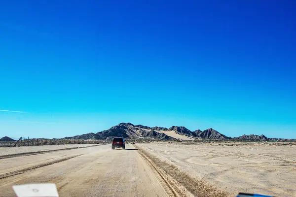 stock image Road in the middle of the Sonora desert with mountanous background. . Puerto Peasco, Sonora, Mexico.